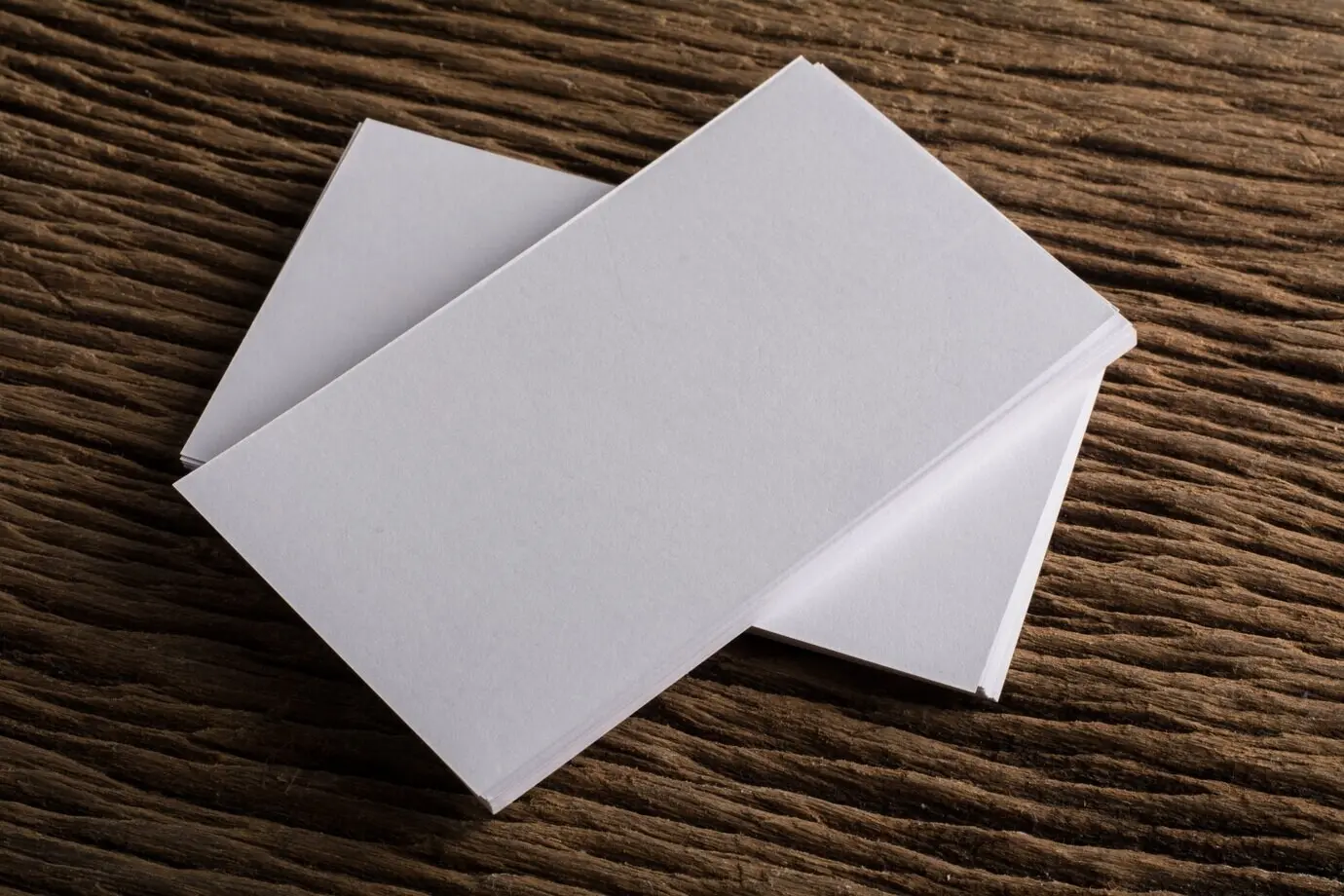 Пустая белая визитная карточка для презентации корпоративной идентичности на деревянном фоне.